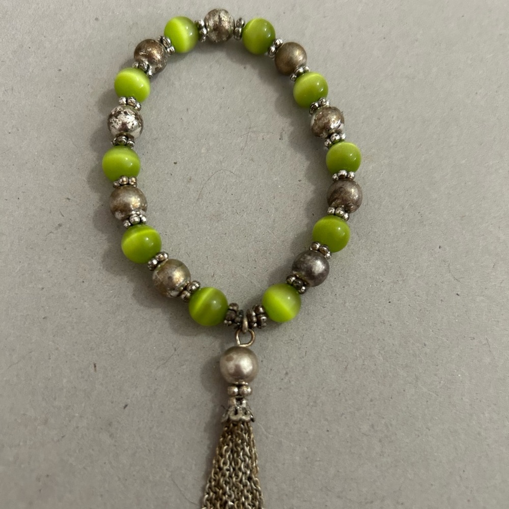 Women’s vintage bracelet.Beautiful green cats eye style beads w/gold tone tassel